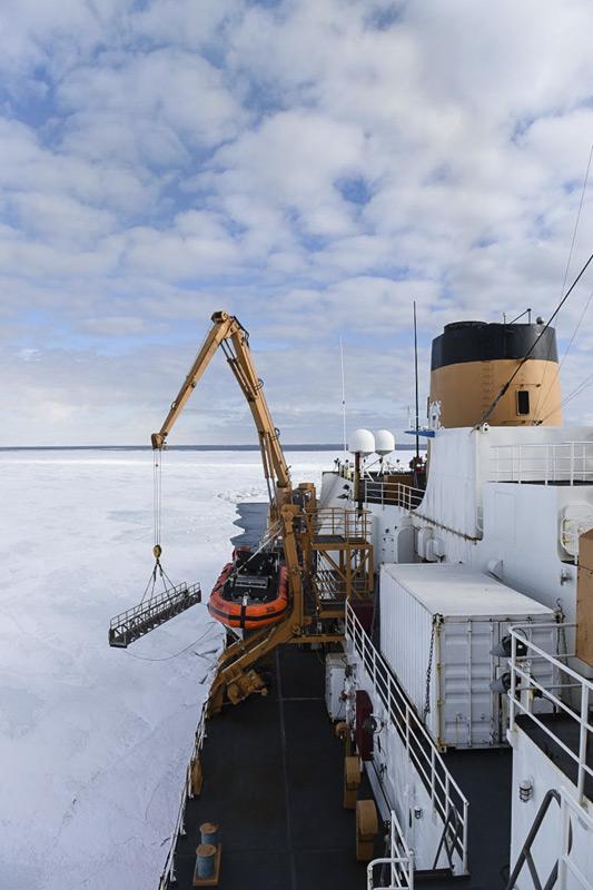 Ein Kranführer senkt die Gangway der Polar Star auf das Eis im McMurdo Sound. Nachdem geeigneten Eis gefunden wurde, konnten Passagier und Crew des Eisbrechers auf dem Eis an Land gehen. (Bild: U.S. Coast Guard)